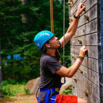 Camper ascends climbing wall
